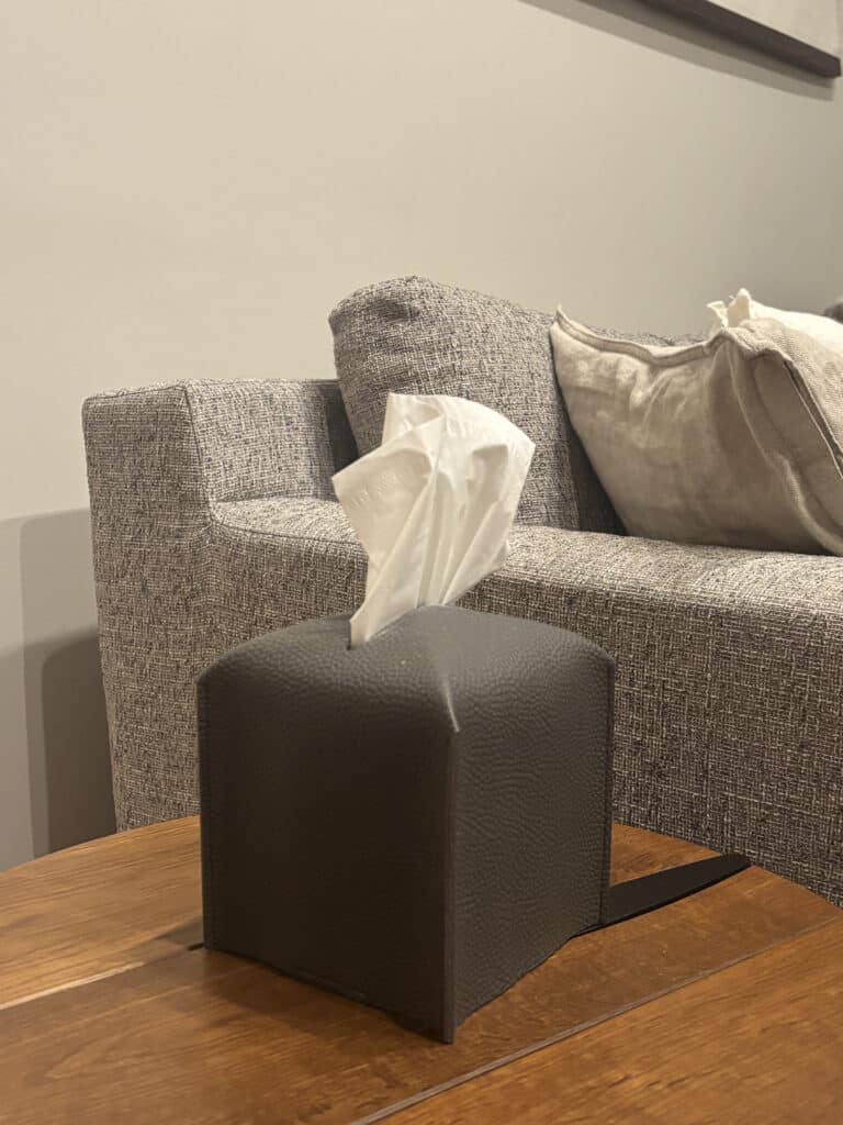 Dark gray textured tissue box with white tissues pulled out