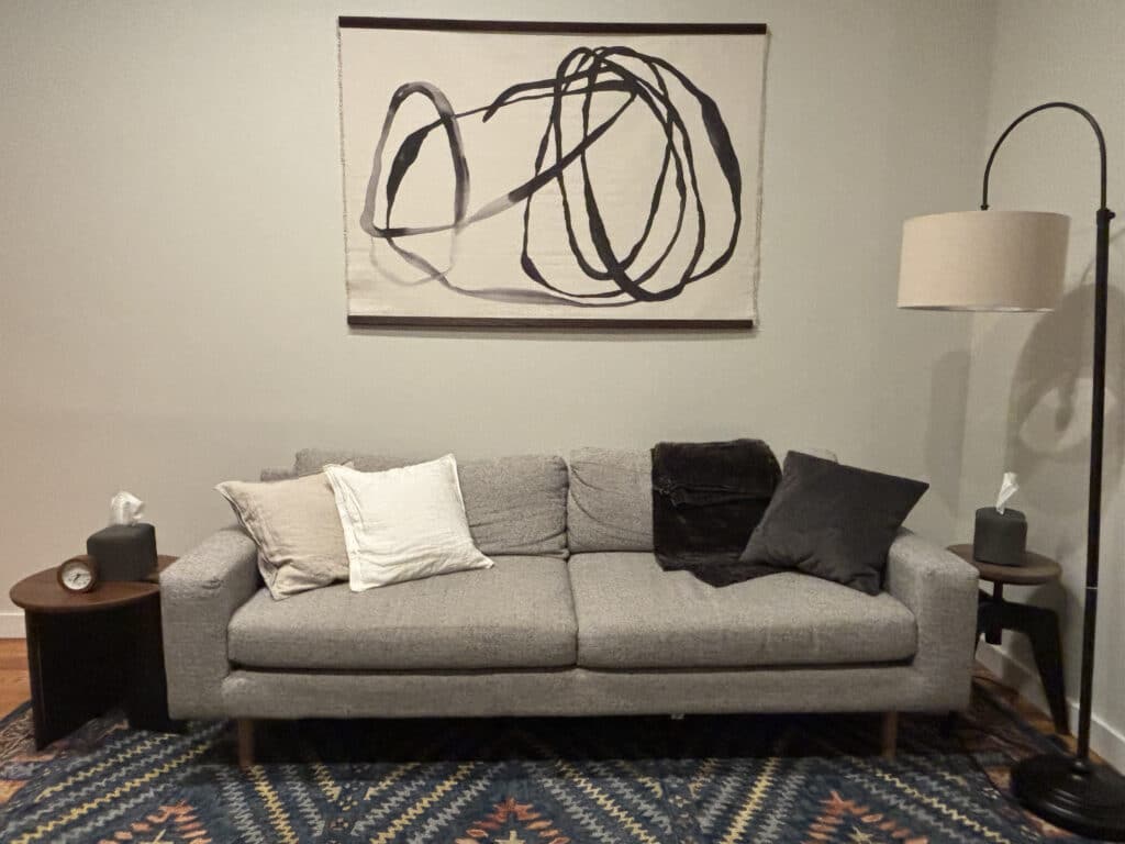 Gray modern sofa with mixed neutral pillows and black throw
