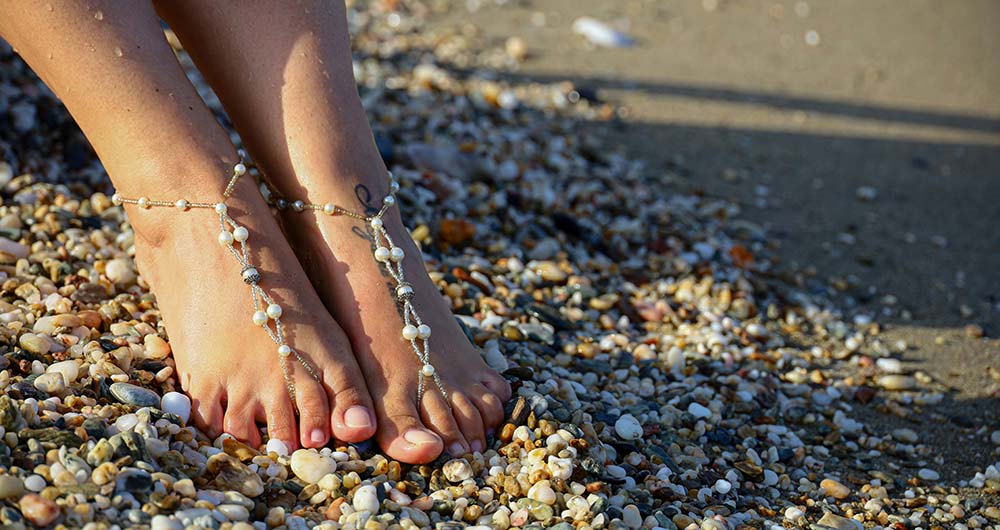 a barefoot woman's feet in a beaded barefoot