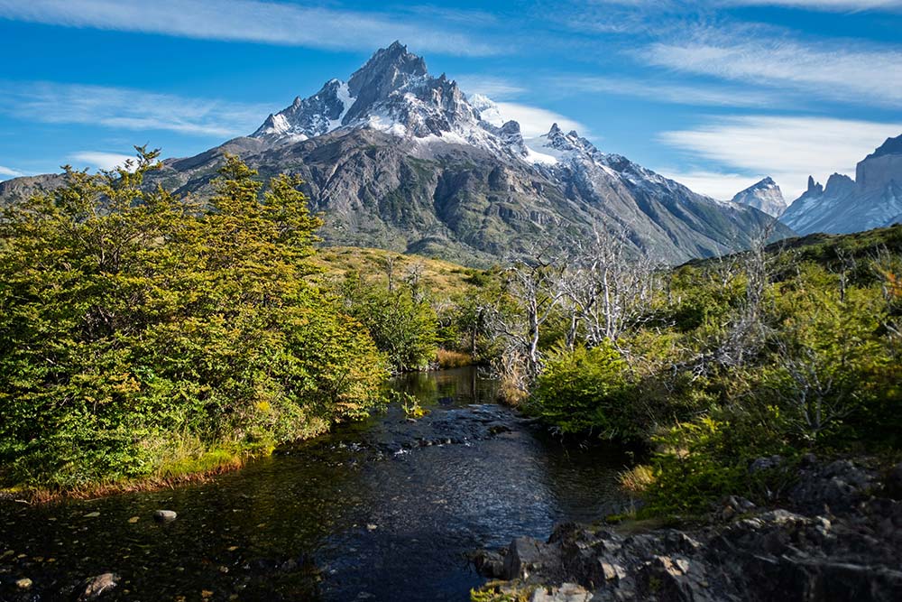 a majestic mountain range overlooking a serene stream