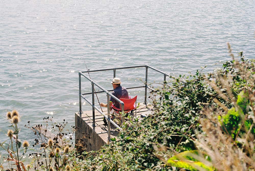 angler fishing from a small platform over the water
