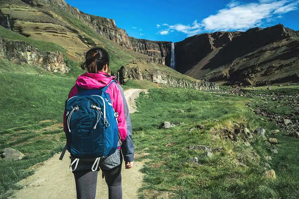 A woman traveler trekking through Iceland’s landscape during summer.