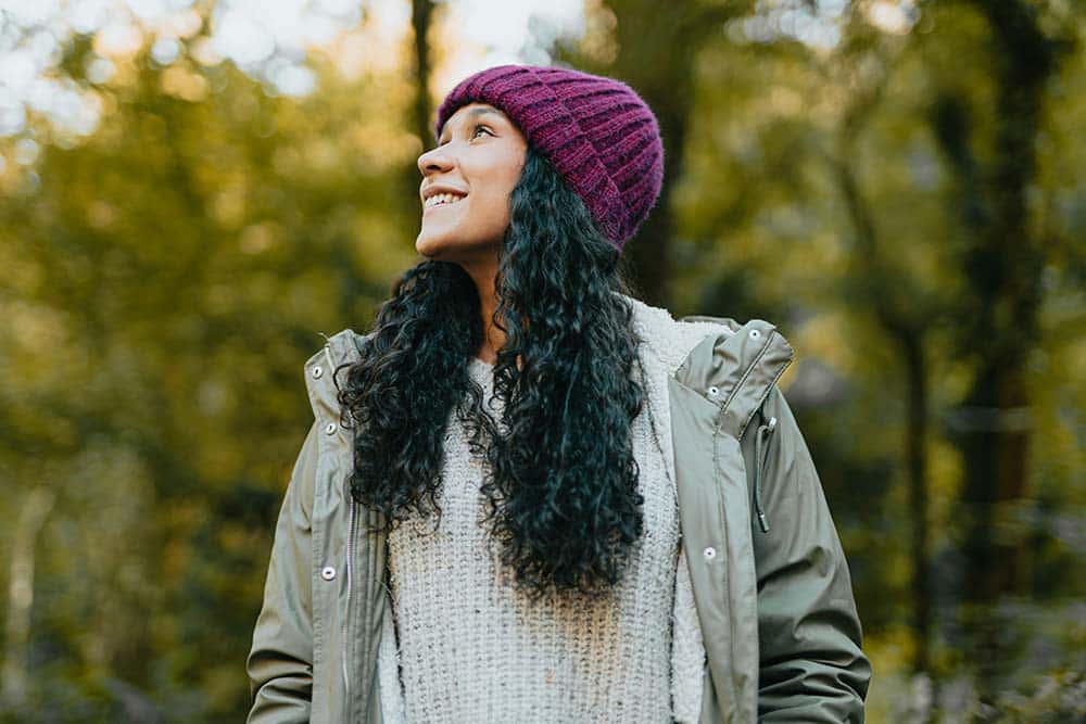 A woman with long black hair wearing a purple hat.