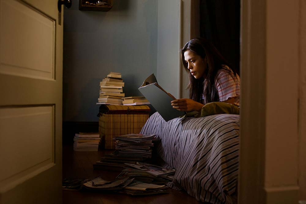 Girl reading magazines in her bedroom at night.