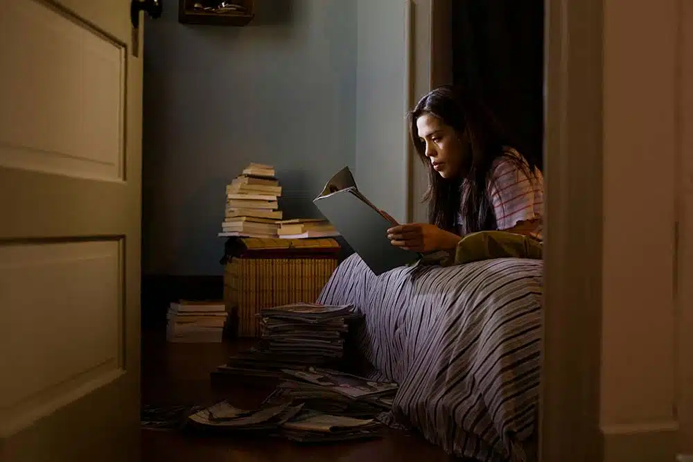 Girl reading magazines in her bedroom at night.