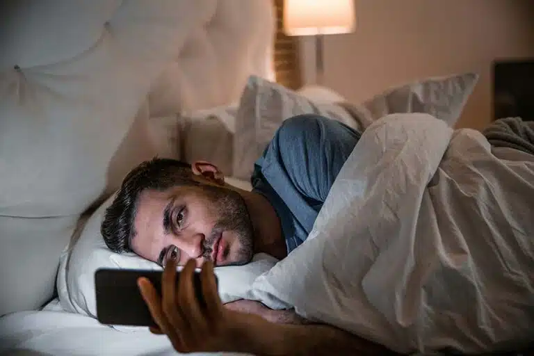 Young man lying comfortably in bed